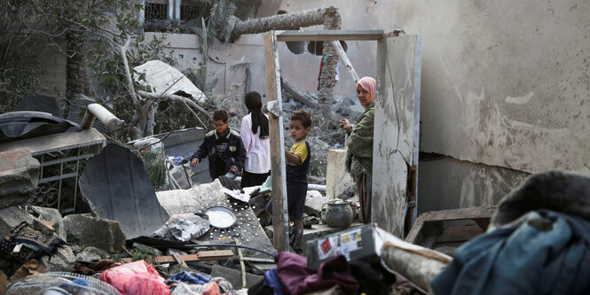 Menschen auf trümmern in Khan Younis, Gaza