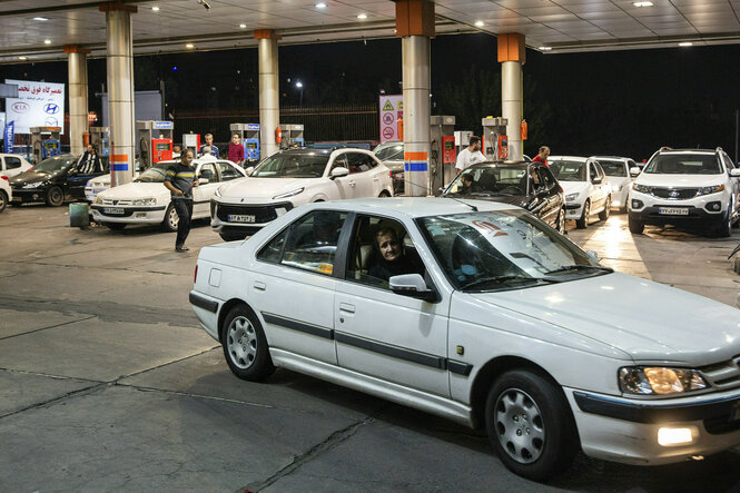 Weiße Autos stehen an einer Tankstelle in der Schlange