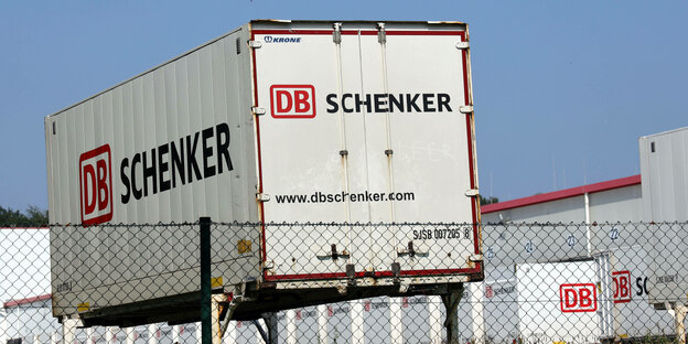 Ein Container auf einem Firmengrundstück hinter einem Maschendrahtzaun