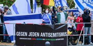 Personen auf einer Demonstration halten Schilder hoch, die sich gegen Antisemitimus aussprechen