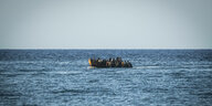 Ein Boot auf hoher See übervoll mit Geflüchteten