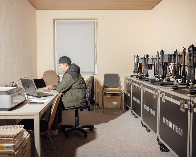 Eine Person sitzt in einem Raum mit Computern.