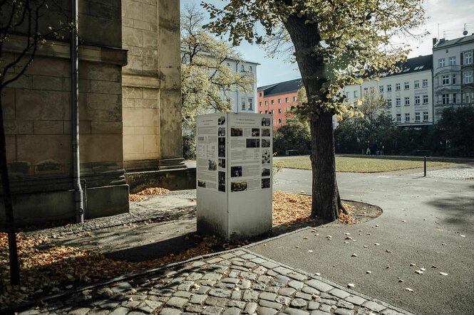 Eine Stelltafel mit historischen Aufnahmen auf dem vorplatz der Elisabeth Kirche