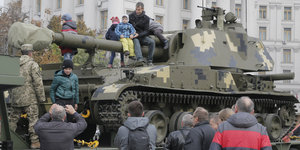 Familien turnen auf einem Panzer herum
