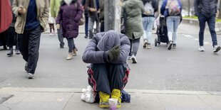 Ein bettelnder Mann sitzt am Hermannplatz in Neukölln