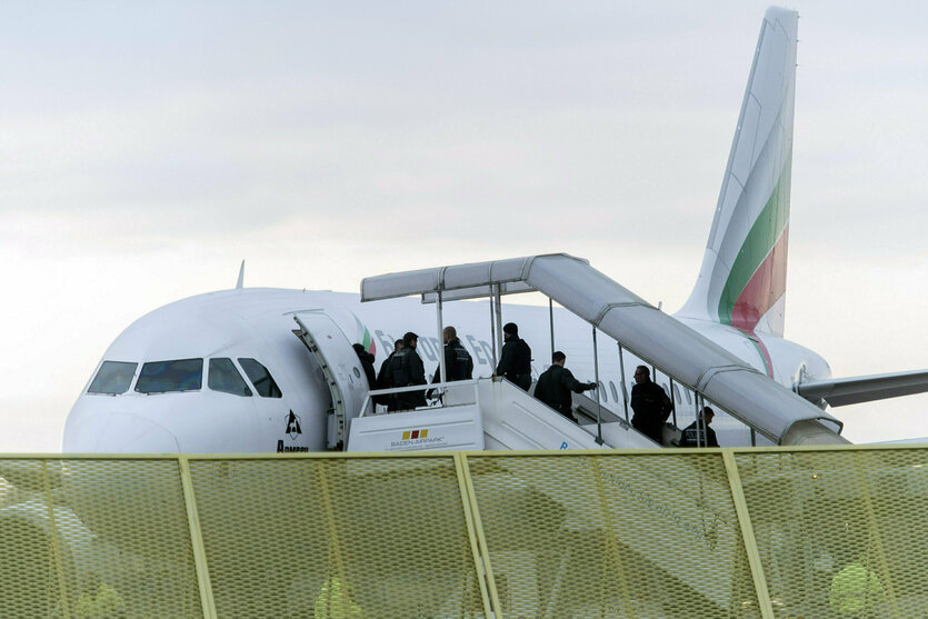 Geflüchtete steigen in ein Flugzeug