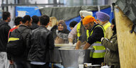 Freiwillige Helfer teilen auf dem Hauptbahnhof Wien essen an Flüchtlinge aus.