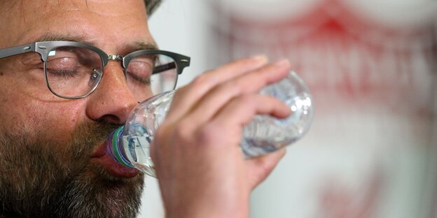 Jürgen Klopp schließt die Augen und trinkt aus einer Wasserflasche