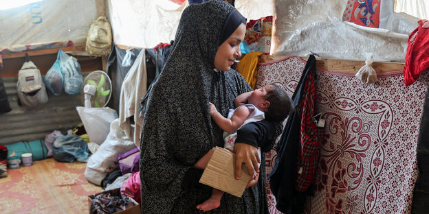 Eine Mutter hält ihre Tochter in einer Notunterkunf in Deir al-Balah im Gazastreifen