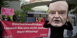 Demonstrant mit Wissmann-Pappkopf , Banner für billigeres Deutschlandticket