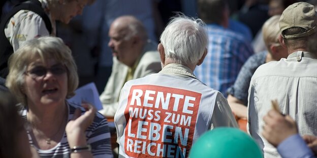 Ein mann trägt eine Weste mit der Aufschrift "Die Rente muss zum leben reichen"