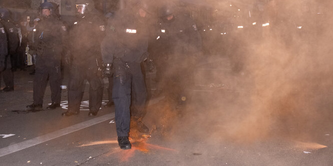 Roter Rauch vor Polizisten.