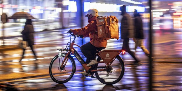 Lieferando Fahrer fährt durch den Regen