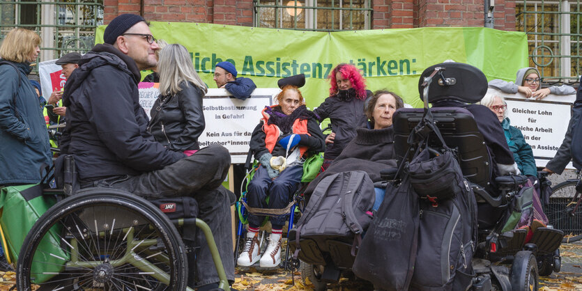 Einige Menschen im Rollstuhl auf einer Kundgebung bei der Senatsverwaltung für Soziales.