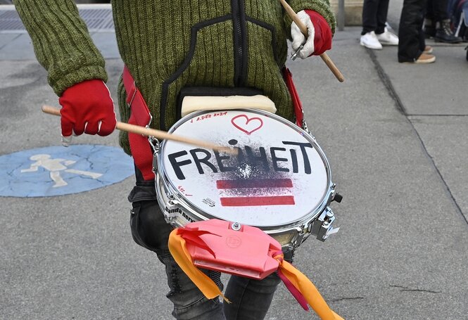 Jemand schlägt auf eine Blechtrommel. Auf dem Trommelfell steht das Wort "Freiheit"