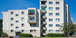 Ein weißes Mehrfamilienhaus auf einer Wiese