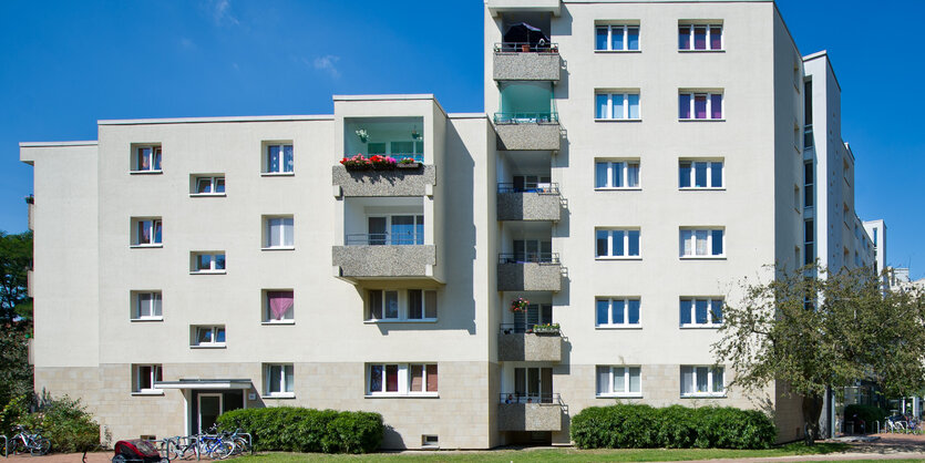 Ein weißes Mehrfamilienhaus auf einer Wiese