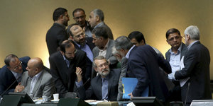 Männer diskutieren im iranischen Parlament