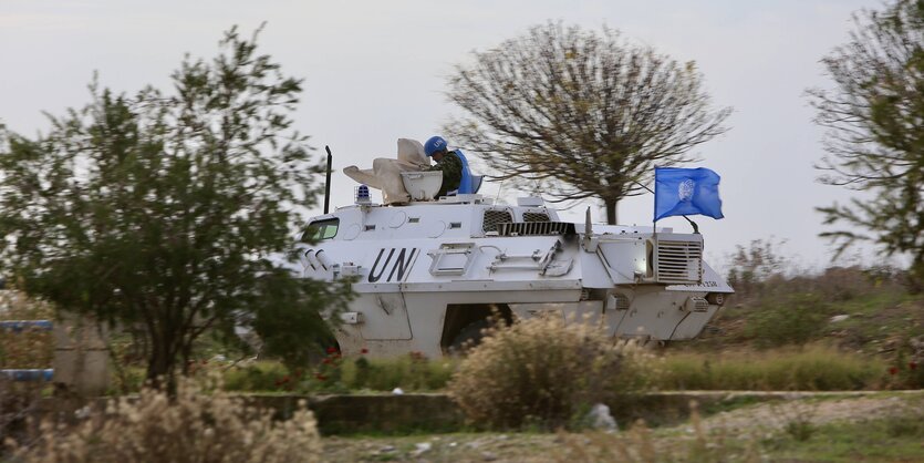 Soldat schaut aus einem UN Panzer mit blauer Flagge heraus