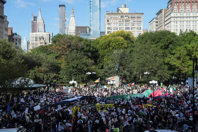 Skyline New Yorker Hochhäuser, eine Menschenmenge demonstriert davor