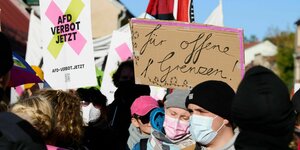 "Für offene Grenzen" steht auf einem Plakat einer Demonstrantin, die an einer Anti-AfD-Demonstration vor der Wiesenhalle teilnimmt. Dort findet der Landesparteitag der AfD Berlin statt.