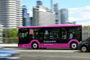 Ein pinkfarbener Bus fährt durch Frankfurt, auf dem Bussteht das Wort: Ersatzverkehr