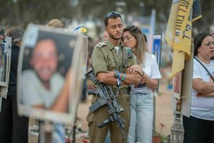 Am Jahrestag des Hamas-Massakers in Israel trauern Menschen mit geschlossenen Augen um die Opfer