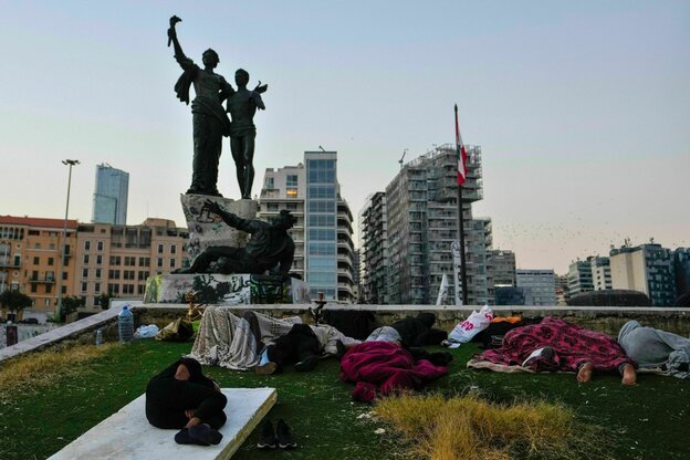 Menschen schlafen vor dem Denkmal auf dem Märtyrerplatz in Beirut