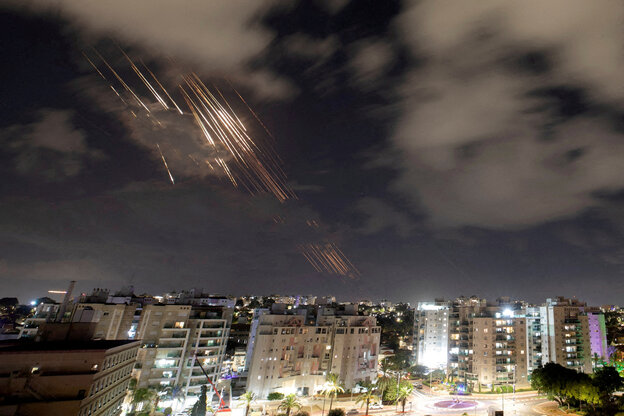 abgefangene Raketen ziehen helle Streifen im Nachhimmel über Hochhäusern