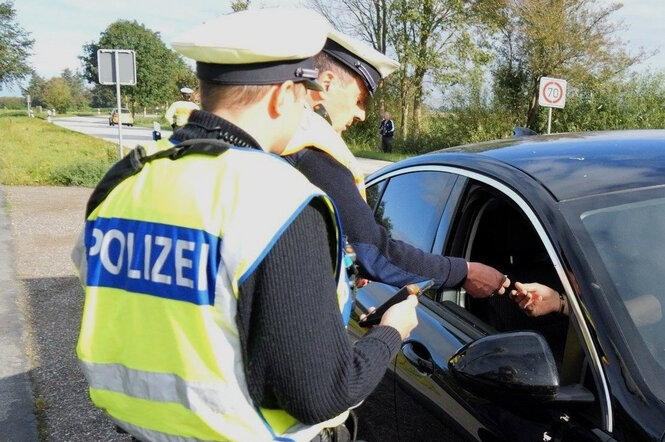 Beamte der Bundespolizei kontrollieren ein Fahrzeug an der deutsch-dänischen Grenze.