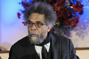 Cornel West steht im schwarzen Anzug vor einem bunt angeleuchteten Blumenstrauß.