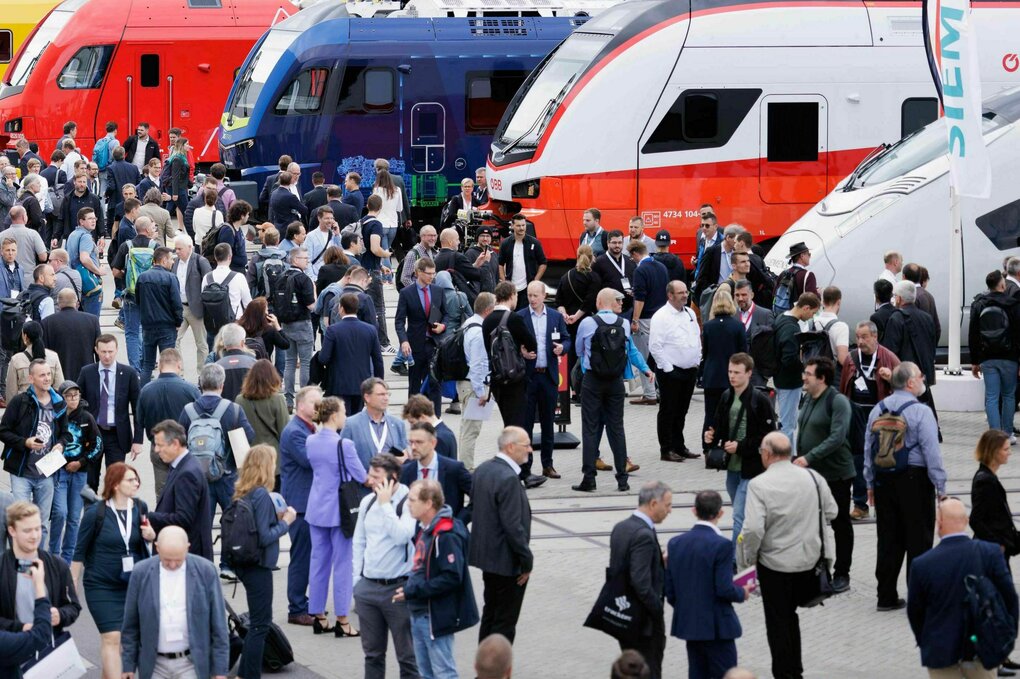 Züge auf einer Messe mit vielen Menschen.