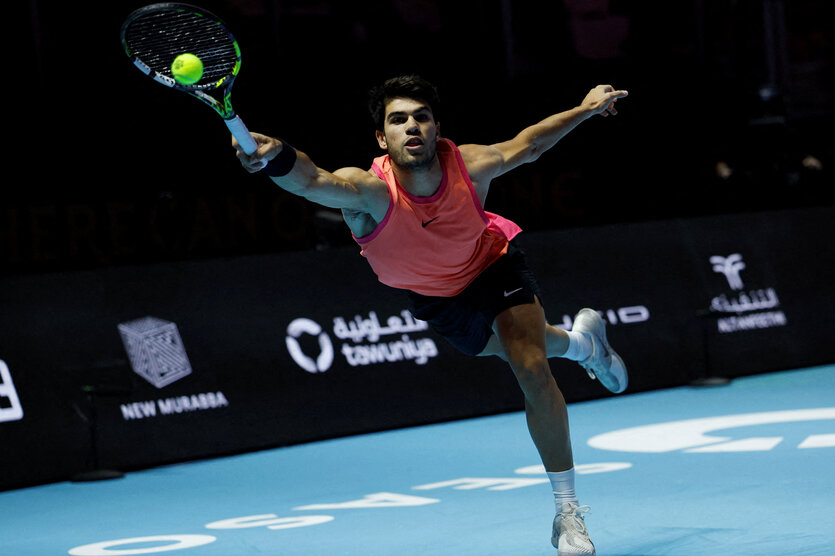 Tennisprofi Carlos Alcaraz, der im Sprung den Tennisball zurückschlägt