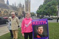 Sarah Fenton steht mit einem Bild ihres verstorbenen Mannes Keith vor dem britischen Parlament