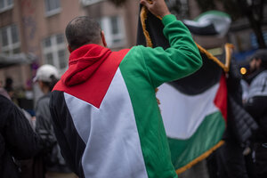 Ein Mann in einem Pulli in den Nationalfarben Palästinas auf einer Demo