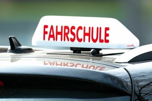 in Schild mit der Aufschrift «Fahrschule» ist auf einem Fahrschulauto befestigt