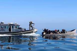 Ein Patrouillenboot der tunesischen Küstenwache stoppt ein kleines Boot mit Flüchtlingen