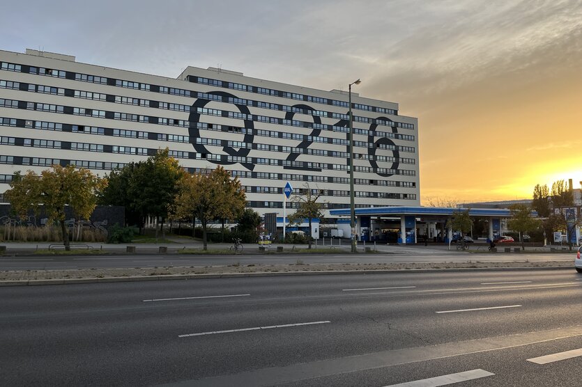 Plattenbau mit Aufschrift "Q216" im Sonnenuntergang