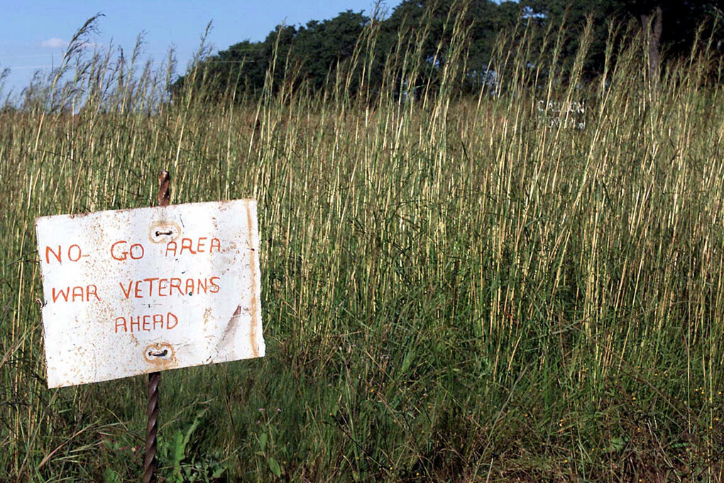 Ein Warnschild "No Go Area: War Veterans Ahead" auf einem überwucherten Feld