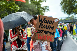 Auf einer Demonstration in Berlin hält eine Frau ein Schild mit der Aufschrift: Wohnraum ist keine Ware