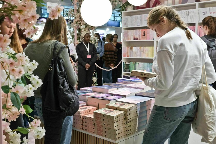 Junge Buchinteressierte schauen sich auf der Buchmesse Bücher an