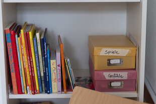 Bücher sowie zwei Kisten mit den Aufschriften "Spiele" und "Gefühle" sind im Büro der Schulsozialarbeiter an der Emil-Gött-Schule zu sehen.