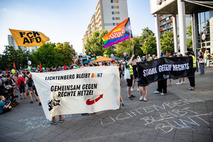 Demonstration auf einem Platz, auf den Bannern steht „Lichtenberg bleibt bunt, gemeinsam gegen rechte Hetze“