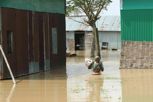 Ein Mann watet durch Hochwasser