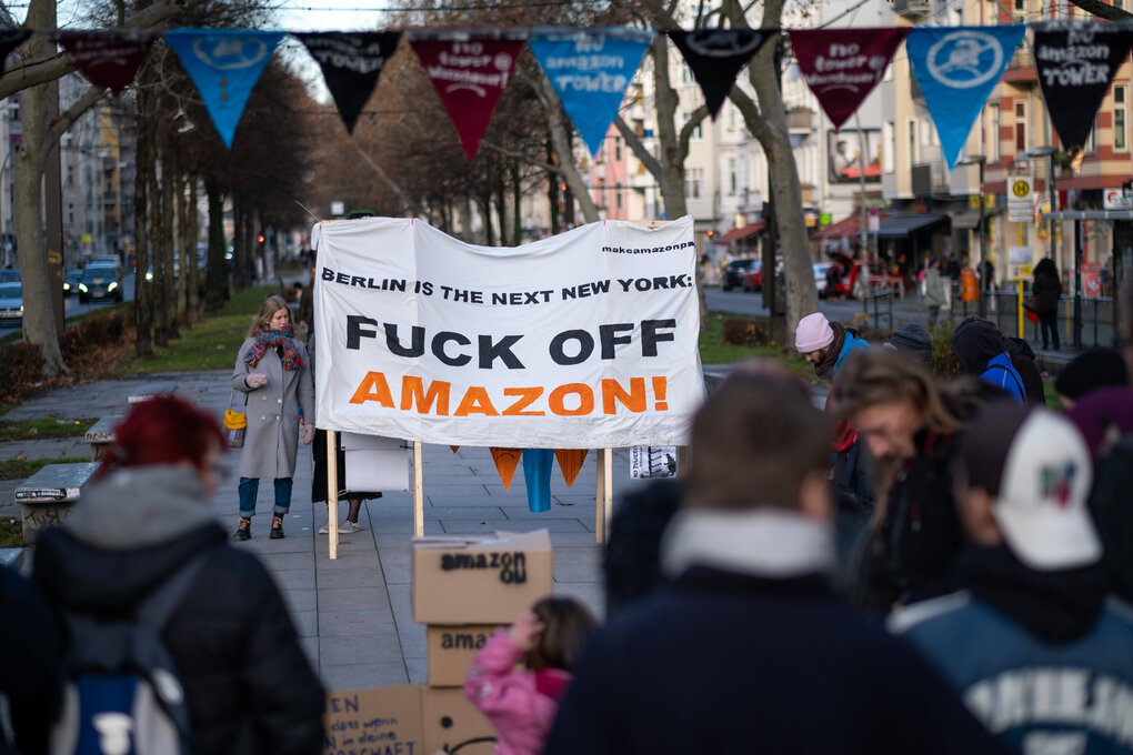 Proteste des Bündnisses Berlin vs. Amazon gegen den Amazon-Tower an der Warschauer Brücke am 21.12.2019. Auf dem Transparent steht: “Berlin is the next New York. Fuck Off Amazon”.