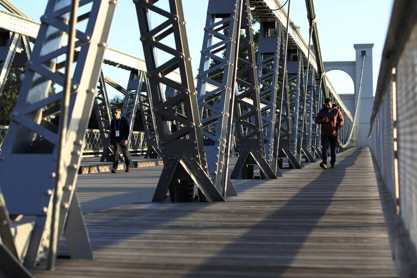 Zwei Personen laufen über eine Brücke