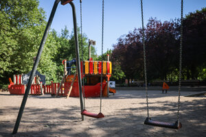 Zwei Schaukeln und ein buntes Spielschiff in einem Park