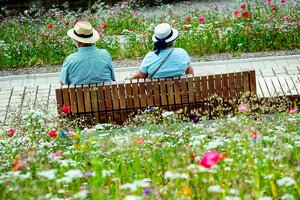 Ein Ehepaar mit Hüten sitzen auf einer Parkbank