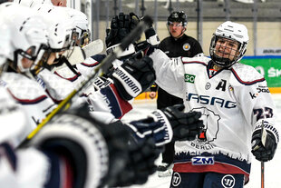 Eishockeypielerin von den Eisbären klatscht die in einer Reihe stehenden Mitspielerinnen ab