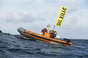 Ein Schlauchboot unterwegs im Meer, Aktivisten in Schutzanzügen und eine Flagge auf der steht: Oil kills